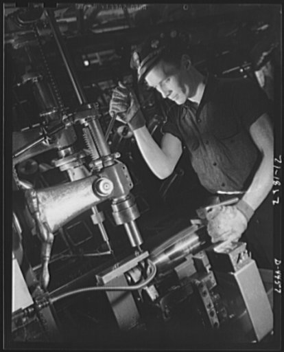 Conversion. Auto parts to artillery shells. A drilling operation on the noses of artillery shells is performed with speed and efficiency in a converted Midwest auto plant. Continuous conveyers feed the shells to the operators to ensure steady production