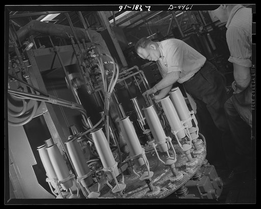 Conversion. Auto parts to artillery shells. Artillery shells pass through a continuous automatic paint-spraying operation in which protective coatings are applied to all inside and outside surfaces. Location: a converted Midwest auto plant