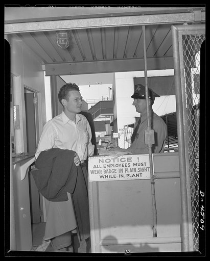 Car pooling at Lockheed Vega. Arrangements are made by phone, and Don's car is left at home. The few miles left in those tires of his can be used for emergency, or the car may be put completely out of service for the duration. Here, Don leaves the plant ready for the trip home under new car pooling 
