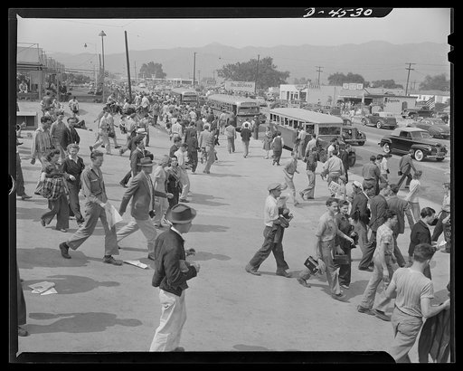 Car pooling at Lockheed Vega. The old clunker in front is a school bus, serving a nearby rural community. School busses can transport both war plant warriors and school children in most cases, and may be the solution to transportation problems of workers living in small communities
