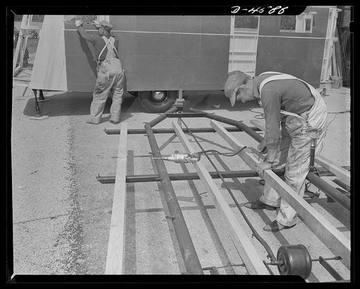 Production. War housing trailers. Stepped-up production of war housing trailers caused an assembly line to overflow into a plant yard at both ends. View of the spill-over assembly line of Western Trailer Company at Los Angeles. Chassis seen here have been much simplified over former types, using a m