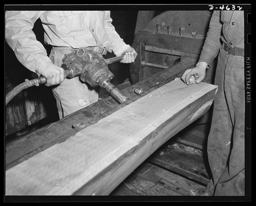Production. Veneer for aircraft and other war essentials. A walnut half log is bolted on the stay log of a machine that will cut it smoothly and with great precision into veneer for our combat planes. Louisville, Kentucky