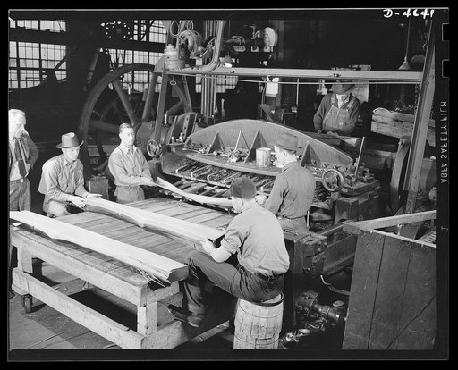 Production. Veneer for aircraft and other war essentials. Veneer for combat planes. In the "half-round method," a half log, after being heated in water to the proper temperature, is bolted on a stay log and revolved against a stationary knife. The sheets, as they fall from the knife, are stacked in 