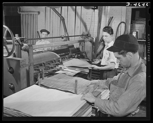 Production. Plywood for aircraft and boats. Strong, light plywood for our fighting planes. An exact and even spread of urea glue is applied by machine to strips of wood veneer to permit attachment to lumbercore panels in a Midwest plant. Louisville, Kentucky