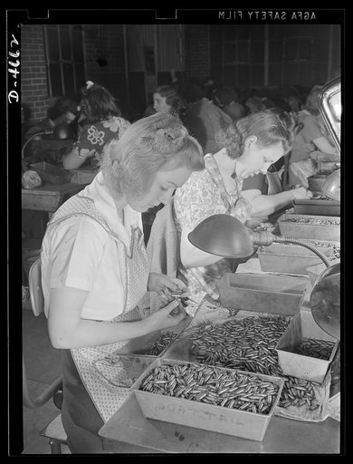 Conversion. Animal traps to armor-piercing bullet cores. Inspecting cores for armor-piercing bullets in a converted Eastern plant that formerly made animal traps. Every bullet must pass several tests for weight, profile, etc.. Small and very accurate guages are used by young women who have been trai