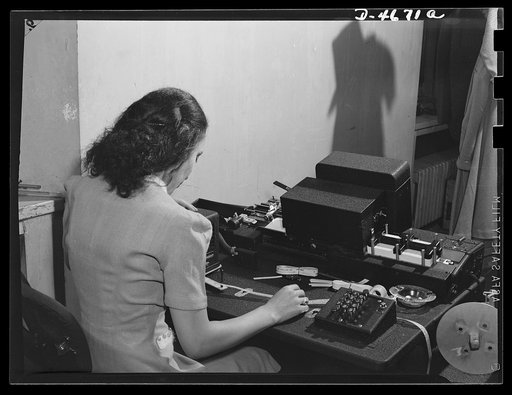 ODT system of port control. Mrs. Elsie Maddox, automatic key punch and tabulator operator in the ODT (Office of Defense Transportation), feeds the punched tape through the machine that marks the cards on traffic movement