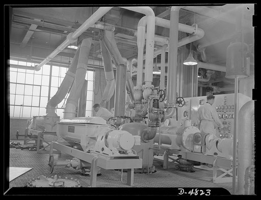 Production. Industrial alcohol. Pressure vessels employ steam and cold water in the process of making industrial alcohol from grain in a converted whiskey distillery. The switchboard in the background provides control of the process by indicating which bins contain grain and which grains are being c