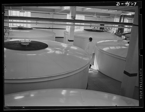 Production. Industrial alcohol. These 40,000 gallon tanks in the fermenting room of a converted whiskey distillery produce industrial alcohol by the action of yeast upon cooked grain whose starches have been changed to sugars by the enzyme action of malt