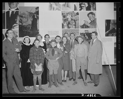 "Open the doors," says Jean Carlu, eminent poster artist, to Manager Sloan of the National and Civilian Defense Exposition at New York's Grand Central Palace. In the background is part of the 15 x 30 foot poster Carlu designed for the Office of Emergency Management (OEM). The panel shown represents 