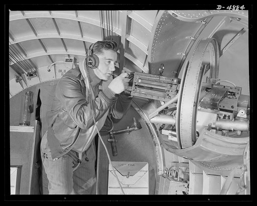 Langley Field, Virginia. YB-17 bombardment squadron. Hitler would like this man to go home and forget about the war. A good American non-com at the side machine gun of a huge YB-17 bomber is a man who knows his business and works hard at it