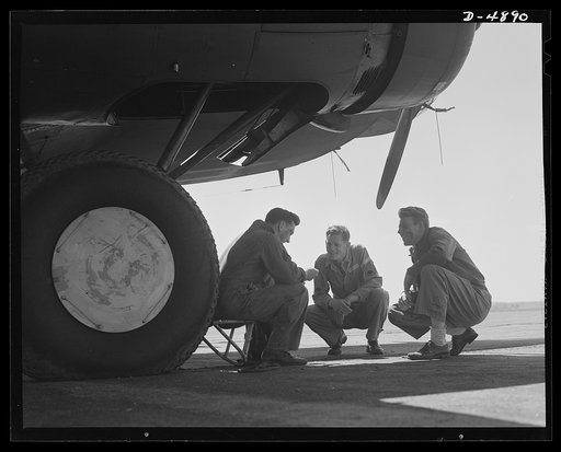 Langley Field, Virginia. YB-17 bombardment squadron. A staff sergeant and two corporals of a bombardment squadron stationed at Langley Field, Virginia thrash out a technical problem that arose during the servicing of the mighty YB-17 bomber that towers above them