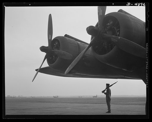 Langley Field, Virginia. YB-17 bombardment squadron. Silhouetted against the dawn, a soldier of a bombardment squadron at Langley Field, Virginia keeps faithful watch over a giant YB-17 bomber.