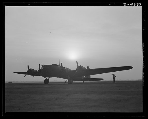 Langley Field, Virginia. YB-17 bombardment squadron. Silhouetted against the dawn, a soldier of a bombardment squadron at Langley Field, Virginia keeps faithful watch over a giant YB-17 bomber.