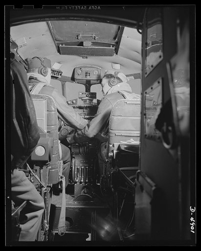 Langley Field, Virginia. YB-17 bombardment squadron. Important business is transcated in the "office" of a mighty YB-17 bomber. The pilot captain and co-pilot lieutenant confer before taking off on a military mission from Langley Field, Virginia