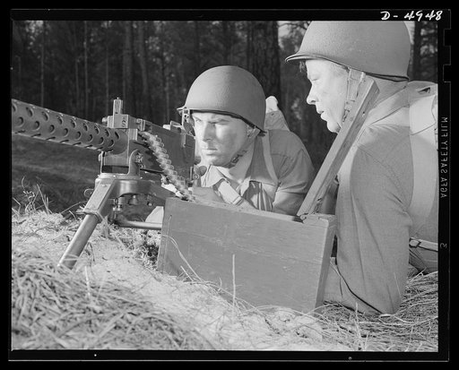 Fort Benning machine gunners. A couple of experts at slowing up the Axis timetable. These two members of a machine gun crew doing post-graduate work at Fort Benning, Georgia have a fast, accurate piece, and they know how to use it