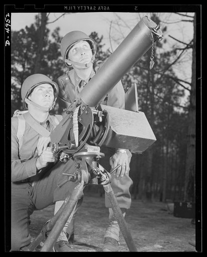 Fort Benning machine gunners. A couple of experts at slowing up the Axis timetable. These two members of a machine gun crew doing post-graduate work at Fort Benning, Georgia have a fast, accurate piece, and they know how to use it