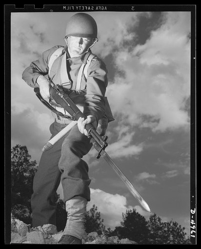 Fort Benning infantry. Slow down, Adolph. The road ahead is blocked. When this fine American soldier, just finishing a hardening up course at Fort Benning, Georgia, gives you the red light, remember he's an expert at stopping traffic
