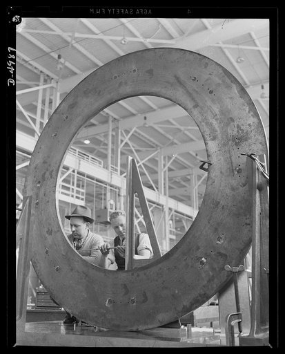 Production. Naval gun mounts. A mount ring for a big naval gun is checked as skilled workers in a large Midwest machine shop complete layouts work that guides later machining operations. Westinghouse, Louisville, Kentucky
