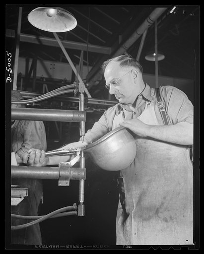 Conversion. Auto radiators to army helmets. Electro-welding a steel rim on an army helmet. The man at the machine is an employee of an Eastern manufacturer whose regular production is radiators for automobiles. He formerly soldered radiator cores. McCool Radiator Company, Detroit, Michigan