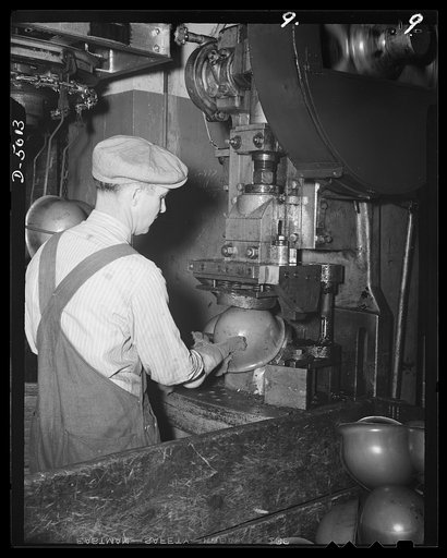 Conversion. Auto radiators to army helmets. The front visor of a steel army helmet is "spanked," or formed into shape. The helmet had an oval shape before this operation, which is performed on one of the many presses of an Eastern plant that formerly made automobile radiators. McCool Radiator Compan