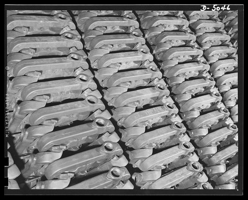 Production. Jeep engines. Manifolds for jeep engines ready to go down the assembly line of a Midwest plant. They'll do their part in helping the tough little cars go places. Continental Motors, Michigan