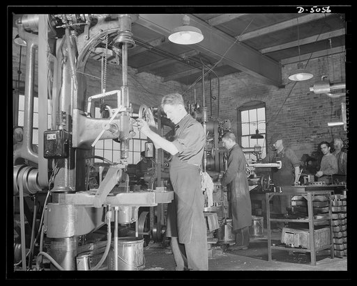 Subcontracting. Bogie-wheel assembly. Spot facing for a bolt and lock washer that holds a bogie-wheel rubbing plate in place on a lever. The work is being done in the machine shop of a small Eastern subcontractor. Painesville Machine Company