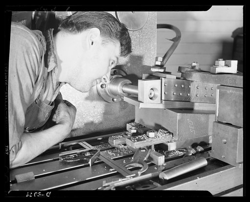 Conversion. Paper machinery to plane wing parts. A horizontal milling machine operator in the plant of an Eastern manufacturer of paper machinery bores a hole in a jig used in the manufacture of airplane wing hinges. In addition to these jigs, the plant is also making open naval sights and other war
