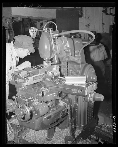 Conversion. Paper machinery to plane wing parts. A vertical milling machine operator planes aluminum stub wing blocks in the plant of an Eastern paper machinery manufacturer who is also making open naval sights and other war essentials