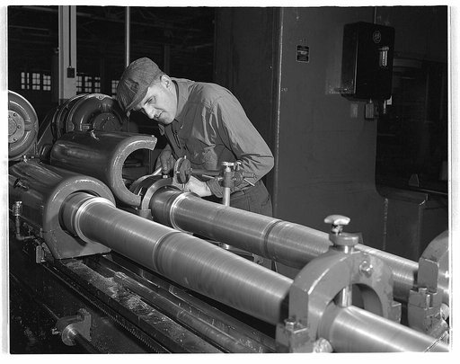 Conversion. Automobiles to 40 mm. anti-aircraft guns. With high-precision instruments, anti-aircraft gun barrels made in a former automobile plant are measured to a ten-thousandth of an inch. Chrysler Corporation, Highland Park, Detroit
