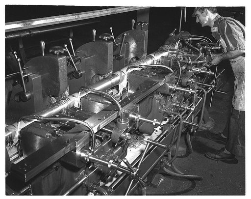 Conversion. Automobiles to 40 mm. anti-aircraft guns. Applying automobile production methods to machining of 40 mm. anti-aircraft gun barrels in a former automobile plant. Five cutting instruments work at the same time. Under the old single-operation methods of gun making, only one of these could wo