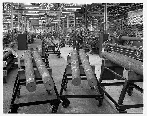 Conversion. Automobiles to 40 mm. anti-aircraft guns. 40 mm. anti-aircraft gun barrels for the U.S. Army are machined and finished in a former automobile plant. First they are cut to size and then their centers located. After that, they go down long machining lines where they are finished by mass pr