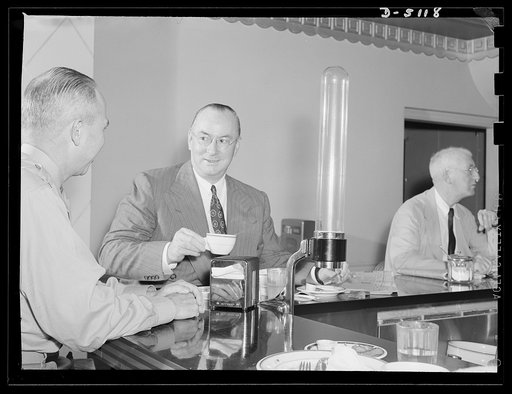 America's production chief. Donald Nelson, America's production chief, streamlines his personal life just as he streamlines the war effort on the home front. Before buckling down to his huge daily task as chairman of the War Production Board (WPB), Mr. Nelson snatches a 7:30 breakfast in the coffee 