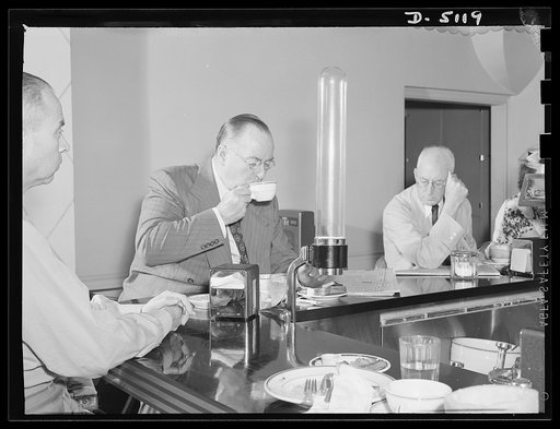 America's production chief. Donald Nelson, America's production chief, streamlines his personal life just as he streamlines the war effort on the home front. Before buckling down to his huge daily task as chairman of the War Production Board (WPB), Mr. Nelson snatches a 7:30 breakfast in the coffee 