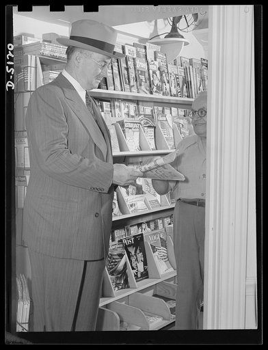 America's production chief. Keeping tabs on the fighting fronts is an important part of Donald Nelson's job as War Production Board (WPB) chairman. He selects a morning paper to read in his car before departing for his office. Later in the day, he will go through the file of metropolitan papers in h