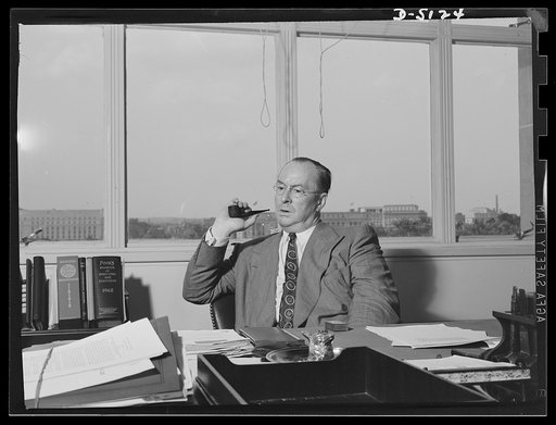 America's production chief. "You see, sir, it's like this..." A typical candid glimpse of Donald Nelson, Chairman of the War Production Board (WPB), as he explains an intricate problem to a visitor. Mr. Nelson has a methodical approach to work, weighing all sides of a problem before he makes a decis