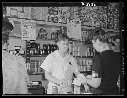 Sugar rationing. The war has brought new purchasing procedures to American consumers. The ration book assures all Americans just distribution of the available sugar on the market. Note the "ceiling prices" posted on the grocery shelves, a guarantee to consumers that prices will not exceed those of M