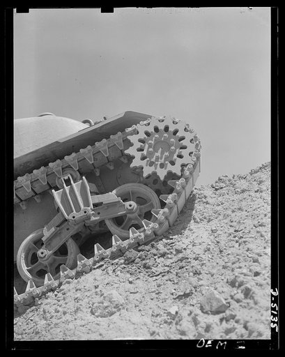 Testing M-4 tanks. A mighty flow of power is carried to the "track" by a driving sprocket of an M-4 tank in a trial run over the test hill of an Eastern manufacturing plant