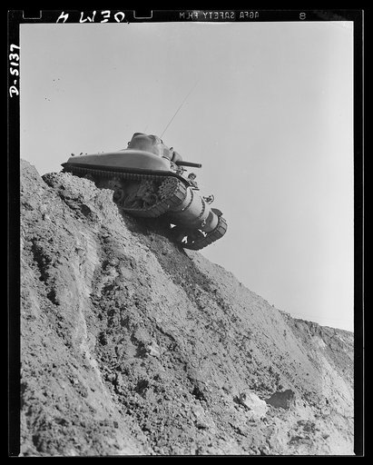 Testing M-4 tanks. Over the top, and ready to go down the steep side of a test hill. A mighty M-4 tank makes successful trial turns at an Eastern manufacturing plant