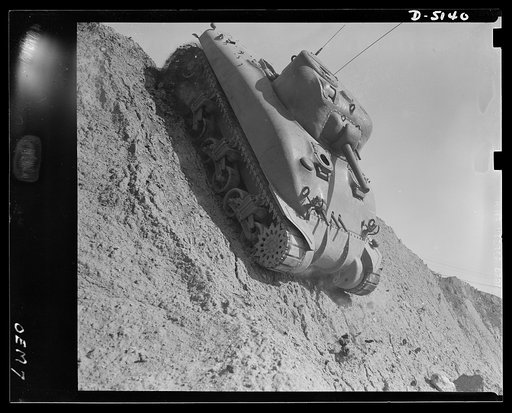 Testing M-4 tanks. Down the steep side of a test hill, as well as up difficult ascents and over many obstacles, a mighty M-4 tank performs brilliantly during the trial runs at an Eastern manufacturing plant
