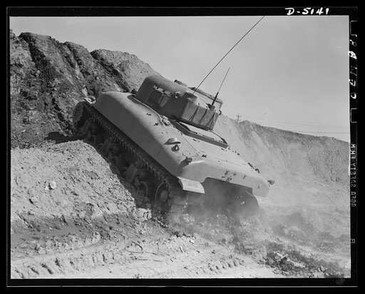 Testing M-4 tanks. Ready to take a stiff grade in loose earth, a mighty M-4 tank performs brilliantly during trial runs at an Eastern manufacturing plant