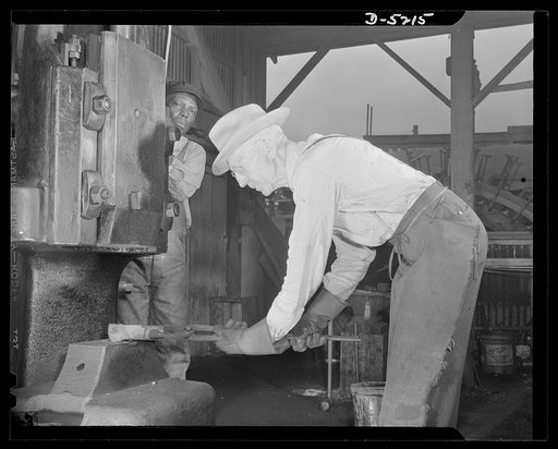 Production. Minesweepers. W.S. Neal, age seventy, came out of retirement to work in the blacksmith shop of an Eastern shipyard. He is shown forging a part to be used in the construction of a Navy minesweeper. Mr. Neal has three granddaughters and a son in war industry. "Why should I sit by at the ag