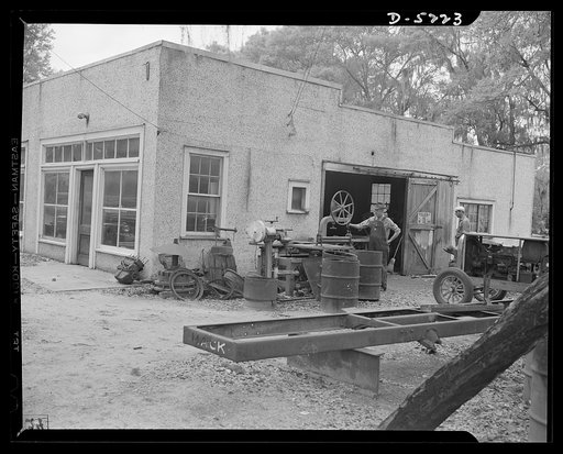 DeLand pool. Bits and parts. Casey's machine shop, down by the railroad tracks in De Land, Florida, is one of the strongest members of the Volusia County pool, now starting on its third million-dollars worth of war production without a single rejection. F.W. Casey, owner of the shop, looks over some