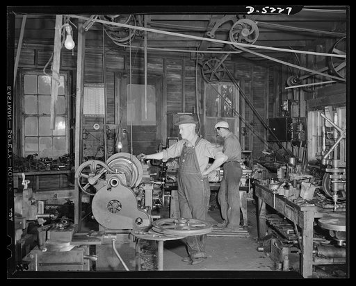 De Land pool. Bits and parts. Casey's machine shop in De Land, Florida doesn't have fluorescent lighting or air conditioning, but it does have the close tolerance machinery needed to make war weapons. Casey and his one-man crew are shown here as they turn out repair racks for airplanes