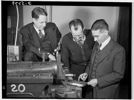 Subcontracting. Passaic home workshop pool. Executives of the Howe Machinery Company, Passaic, New Jersey, discuss details of the production of essential Army equipment with a home workshop owner who is a member of the subcontracting pool organized by the company. Left, Mr. Stanley Carlson, Presiden