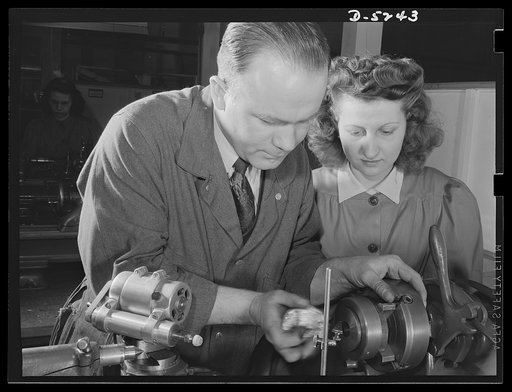 Subcontracting. Passaic home workshop pool. Instructor John Wanelik, of the Howe Machinery Company, Passaic, New Jersey, shows Veronica Stephens how to grind a stripping angle on a cartridge drawing die. A number of young women are being trained for war production jobs in this shop