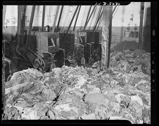 Salvage. Wool reclamation. A battery of rag-picking machines in an Eastern wool-reclaiming plant. These machines shred woolen rags to break them down into wool fiber, which is then mixed with virgin wool. The resulting mixture will be spun into yarns from which new woolen fabrics will be woven