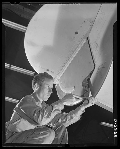 Production. Aircraft. This earnest young worker in a huge Western aircraft plant is completing an assembly on a Vega Ventura bomber
