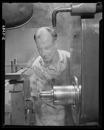 Production. Aircraft. As the bit bites deep into tough metal, this mechinist in a large Western aircraft plant smiles with grim satisfaction. He's ahead of schedule, and he knows that every job completed ahead of time is a sharper thorn in the side of our enemies