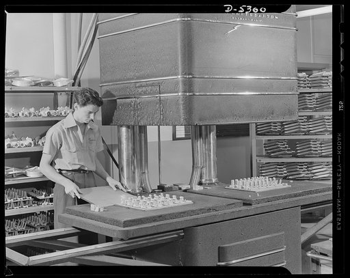 Production. Aircraft. Here's one good reason why refrigerator freezing trays and other aluminum gadgets are out for the duration. On trays in the background are hundreds of aluminum castings going into Lockheed bombers and fighters. Every prime casting is "explored" in a huge X-ray camera like the o
