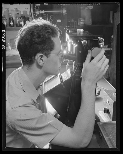 Production. Aircraft. A test engineer in a big Western aircraft plant examines a metal sample through a high-power (2700 diameter) microscope. Representative samples of all structural metals purchased for use in building ships in this plant must pass critical tests to detect faulty materials
